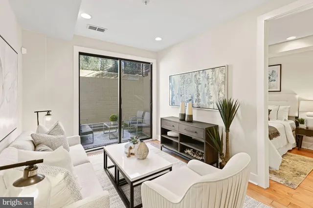 a living room with furniture a flat screen tv and a large window