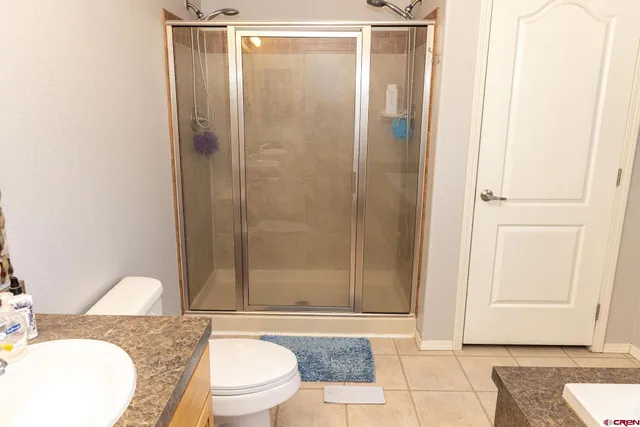 a bathroom with a granite countertop bathtub shower sink mirror and toilet