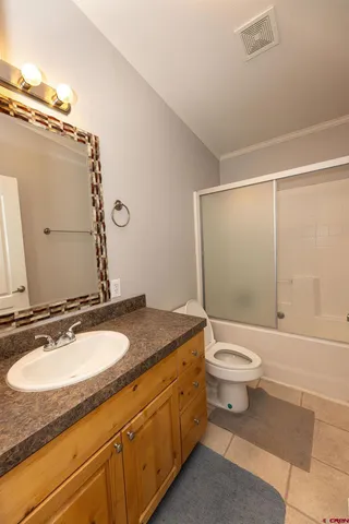 a bathroom with a granite countertop sink toilet a mirror and shower