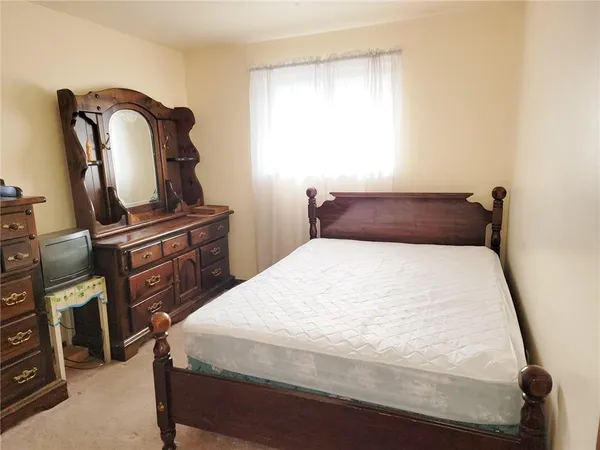 a bedroom with a bed and dresser
