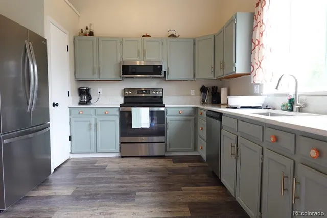 a kitchen with stainless steel appliances granite countertop a refrigerator sink and microwave