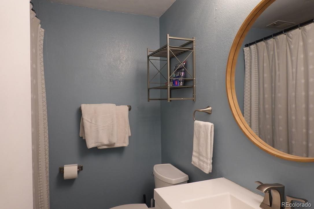 6057 Jay Street Arvada, CO 80003 - Photo 11 of 25 a bathroom with a toilet sink and mirror