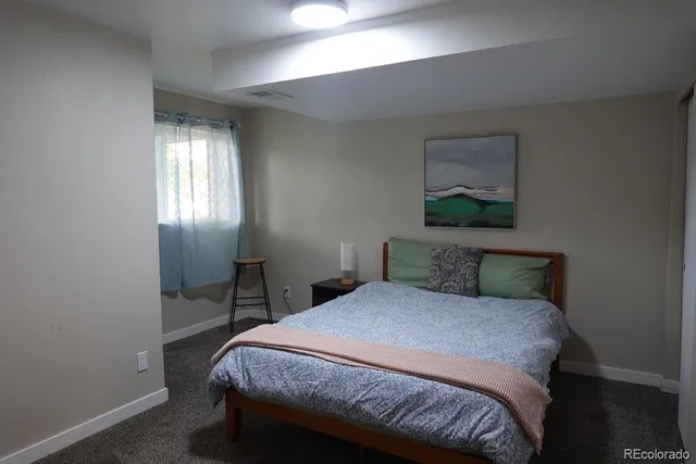 a bedroom with a bed table and window