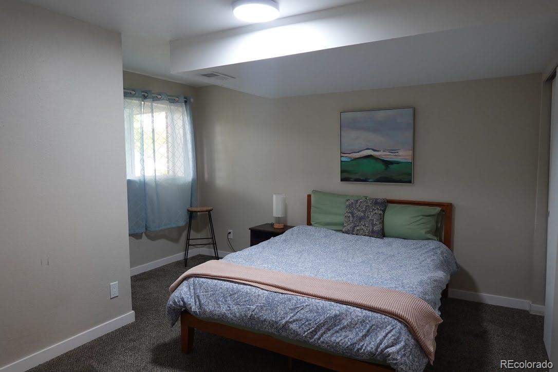 6057 Jay Street Arvada, CO 80003 - Photo 17 of 25 a bedroom with a bed table and window