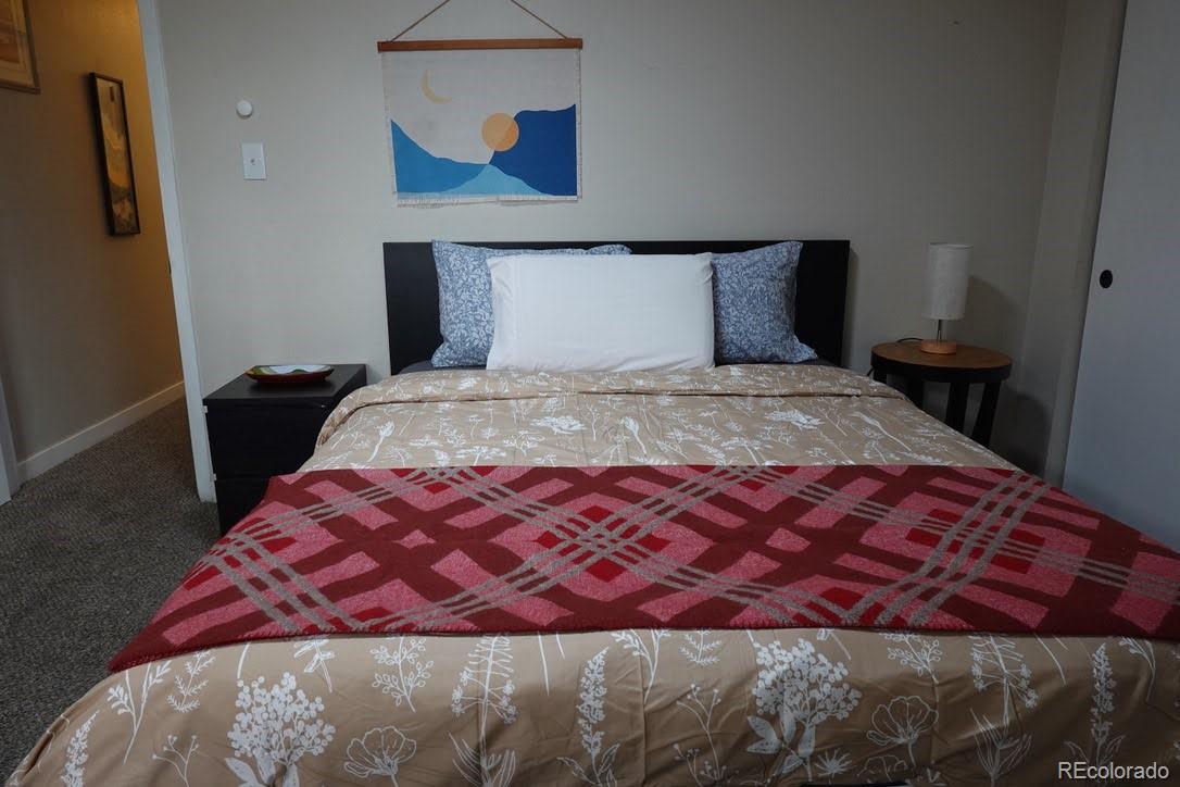 6057 Jay Street Arvada, CO 80003 - Photo 20 of 25 a bed sitting in a bedroom next to a window with a wooden floor