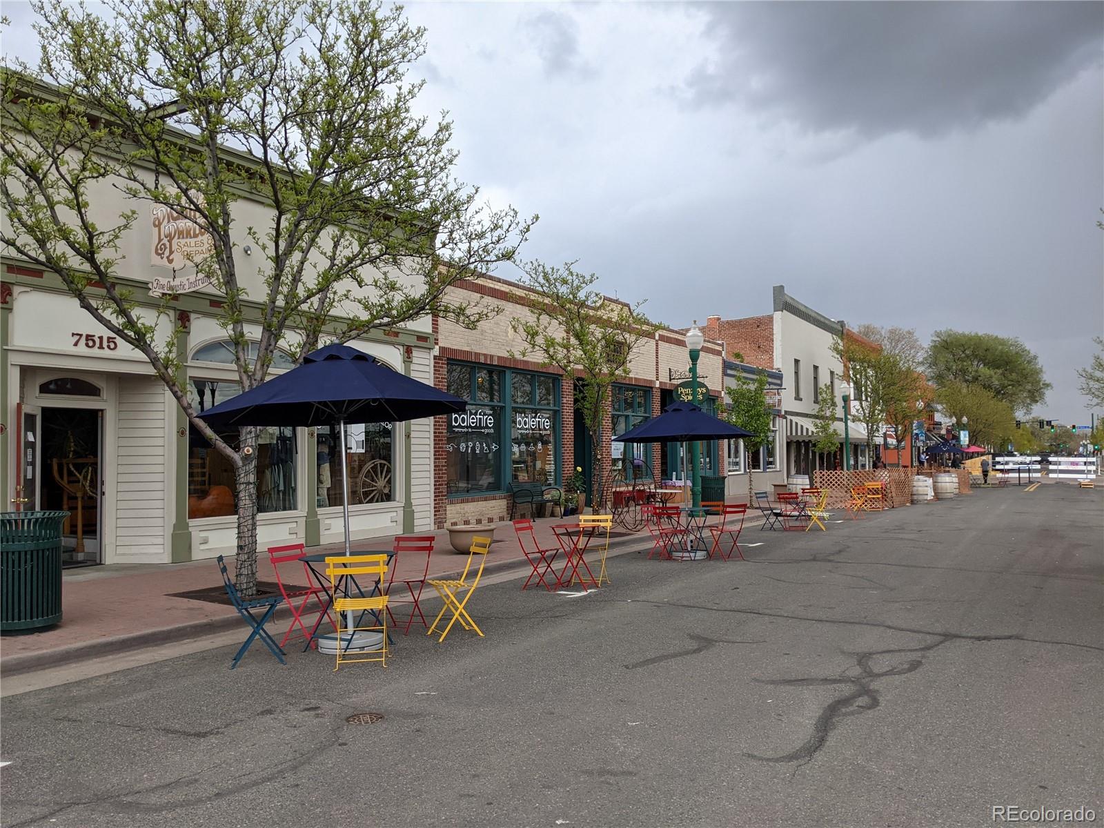 6057 Jay Street Arvada, CO 80003 - Photo 22 of 25 a view of a street with tables and chairs under an umbrella