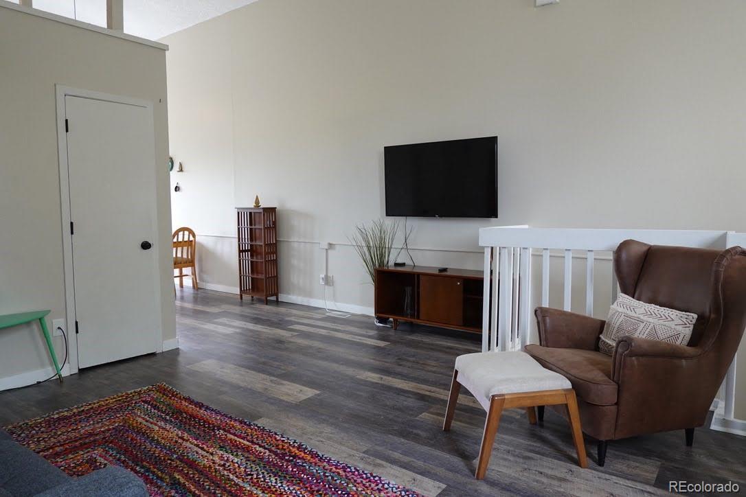 6057 Jay Street Arvada, CO 80003 - Photo 3 of 25 a living room with furniture a flat screen tv and a fireplace
