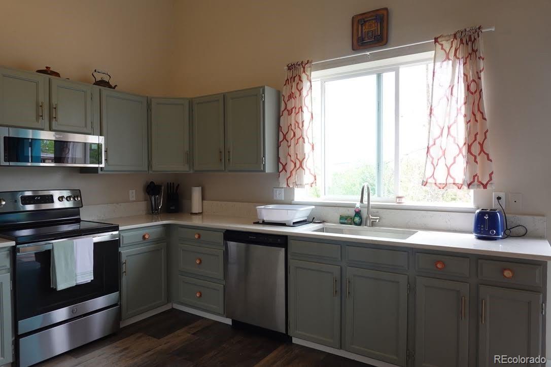 6057 Jay Street Arvada, CO 80003 - Photo 8 of 25 a kitchen with a sink stove and cabinets