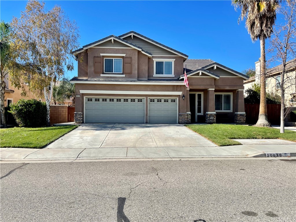 a front view of a house with a garden and trees