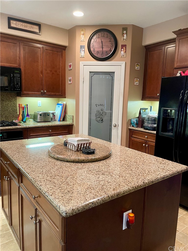 29839 Winter Hawk Road Menifee, CA 92586 - Photo 6 of 21 a kitchen with granite countertop a sink a stove and cabinets