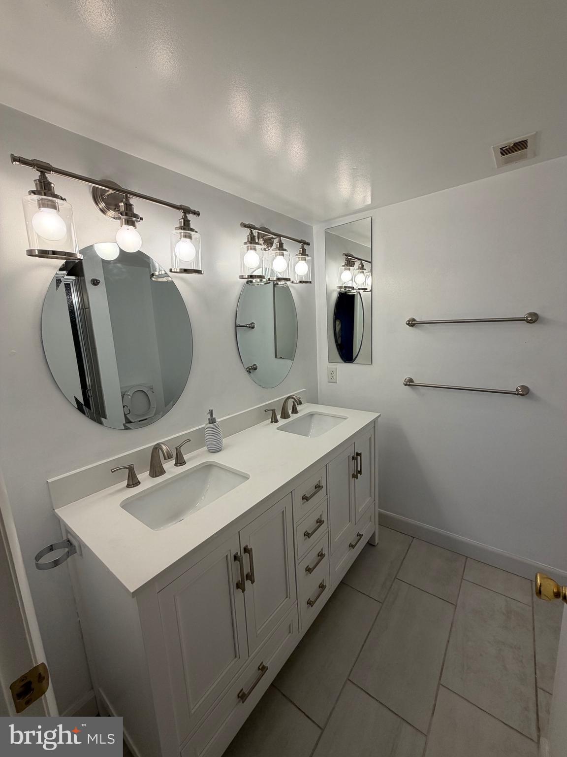 117 Castletown Road, Unit 302 Lutherville-Timonium, MD 21093 - Photo 14 of 15 a bathroom with a double vanity sink and mirror