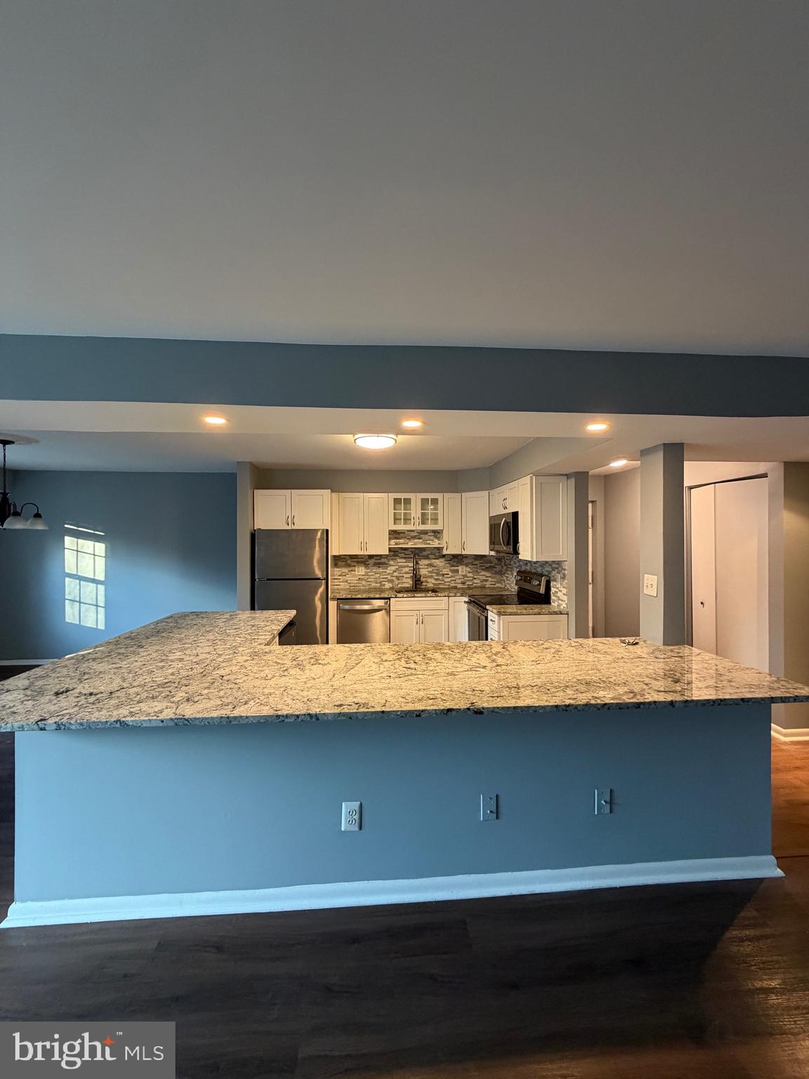 117 Castletown Road, Unit 302 Lutherville-Timonium, MD 21093 - Photo 2 of 15 a kitchen with kitchen island granite countertop a sink a stove and a granite counter top