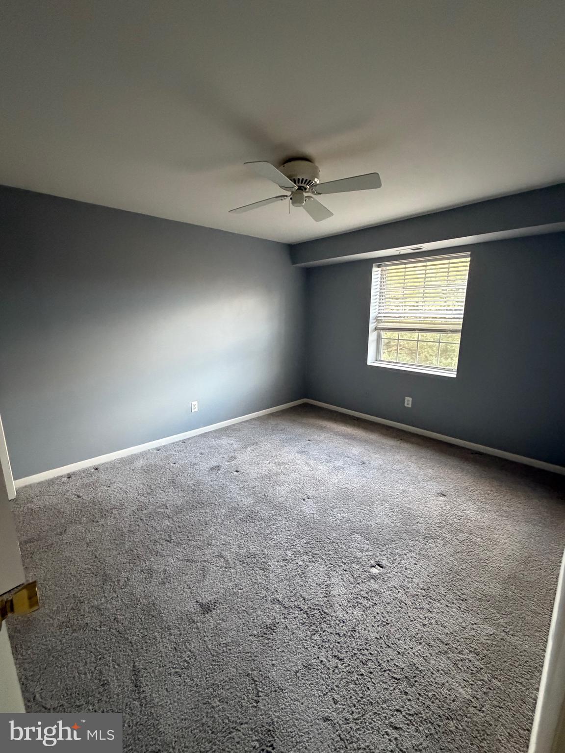 117 Castletown Road, Unit 302 Lutherville-Timonium, MD 21093 - Photo 7 of 15 an empty room with windows and ceiling fan view
