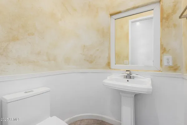 a bathroom with a sink a toilet and mirror