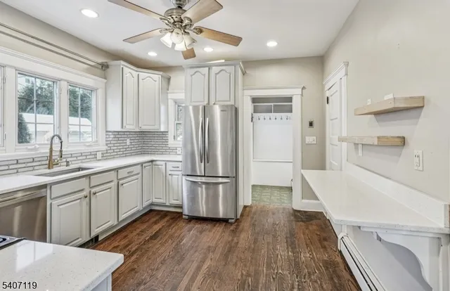 a open kitchen with white cabinets and stainless steel appliances