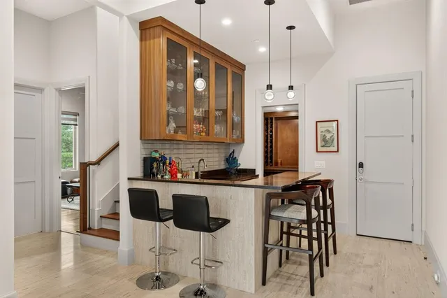 a kitchen with stainless steel appliances a dining table chairs and white cabinets