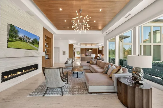 a living room with furniture a chandelier and a fireplace