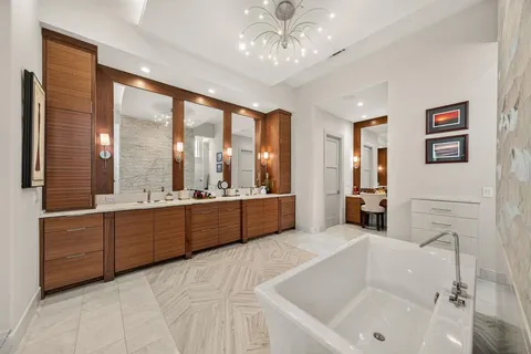 a large white bathroom with a large tub sink shower and mirror