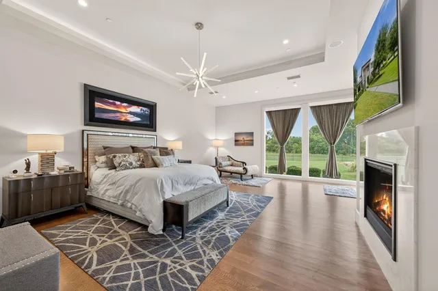 a spacious bedroom with a bed and a flat screen tv