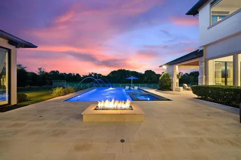 an aerial view of a house with a garden and lake view