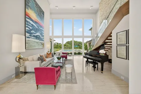 a living room with furniture a large window and a potted plant