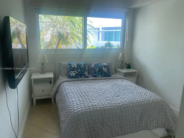 a bedroom with a bed and large windows