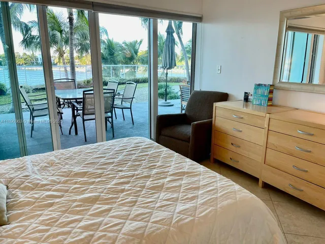 a bedroom with a bed and large windows