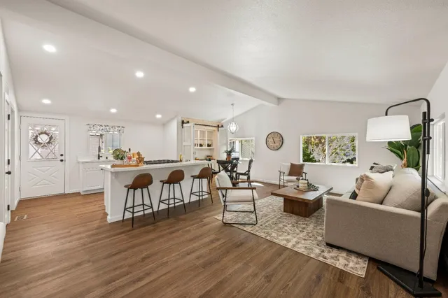 a living room with furniture and a wooden floor