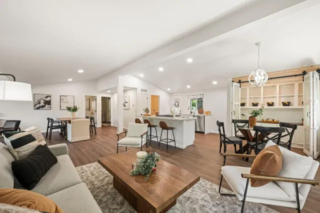 a living room with furniture kitchen view and a table