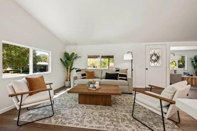 a living room with furniture wooden floor and a table