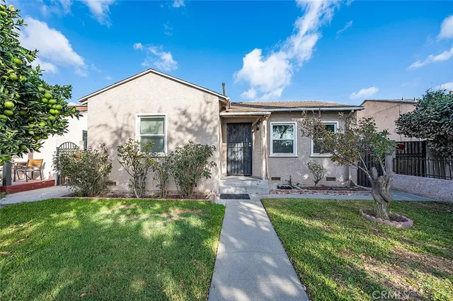 a front view of house with a garden