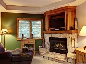 655 4 O Clock Road, Unit 109 Breckenridge, CO 80424 - Photo 1 of 17 a living room with furniture a fireplace and a flat screen tv