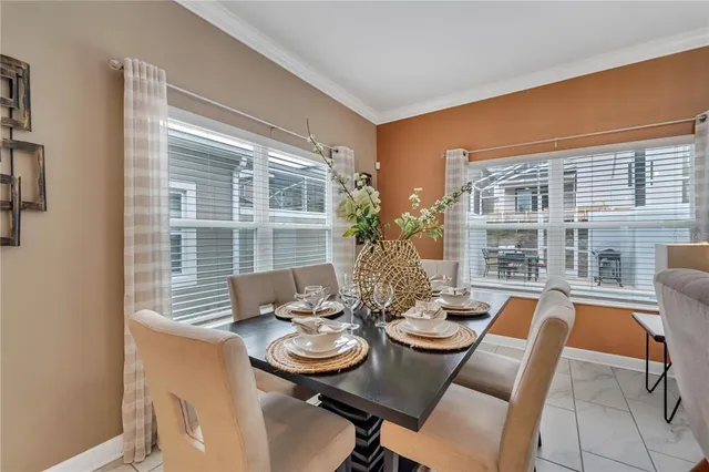 a very nice looking open dining room with kitchen island furniture a chandelier a large window and kitchen view