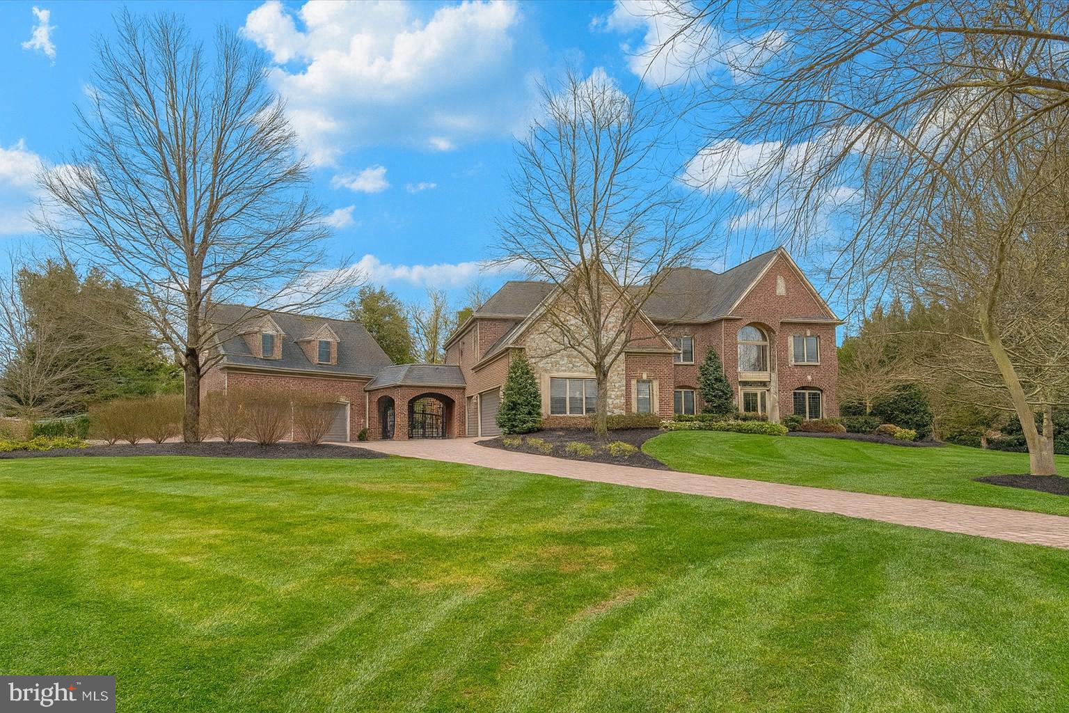 a view of a house with a big yard and large trees