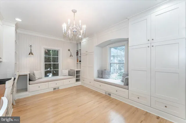 a large white kitchen with a window and white cabinets