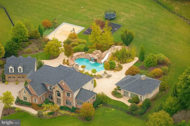 an aerial view of residential houses with outdoor space and swimming pool