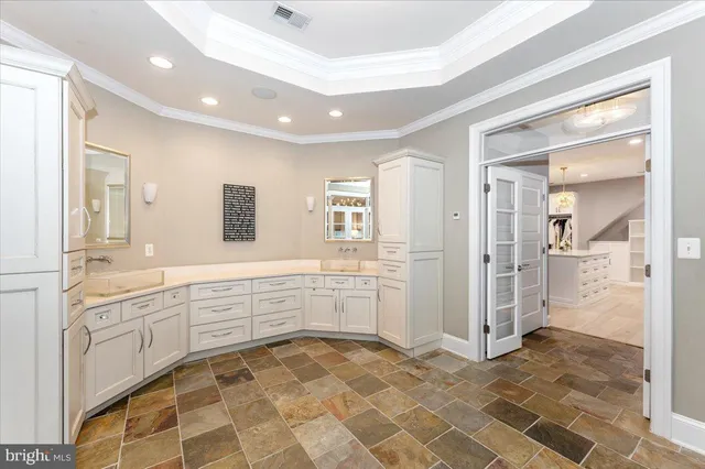 a spacious bedroom with a bed and a flat screen tv