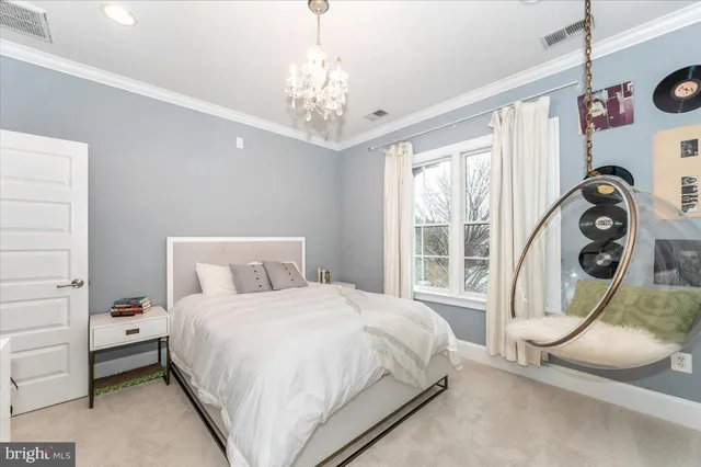 a bedroom with a large bed and a chandelier