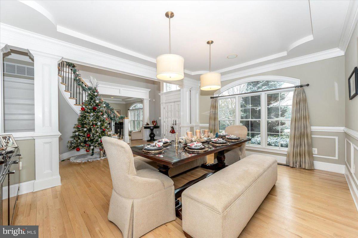 11793 Frederick Road Ellicott City, MD 21042 - Photo 7 of 46 a dining room with wooden floor a chandelier a wooden table and chairs