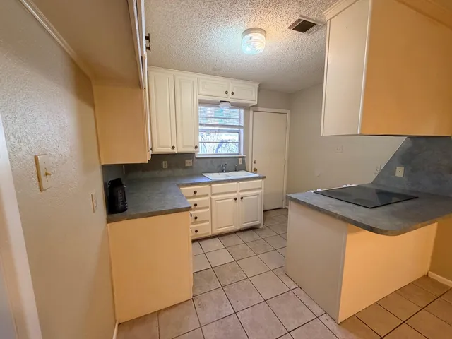 a kitchen with a sink a stove top oven and cabinets