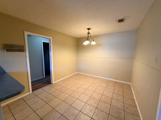 an empty room with kitchen view