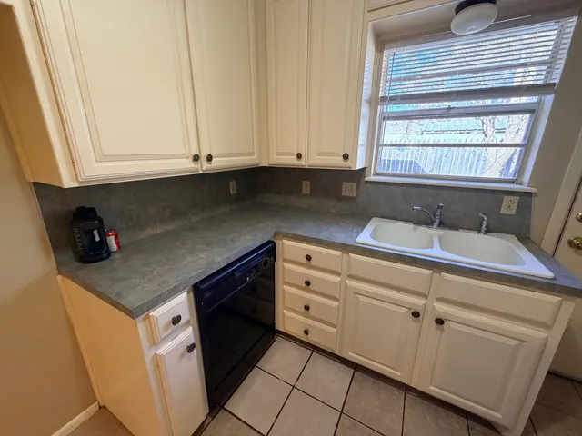 a kitchen with granite countertop white cabinets and sink