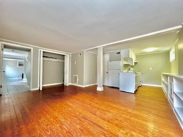 a view of empty room with wooden floor