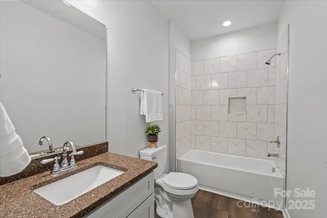 a bathroom with a granite countertop sink mirror toilet and bathtub