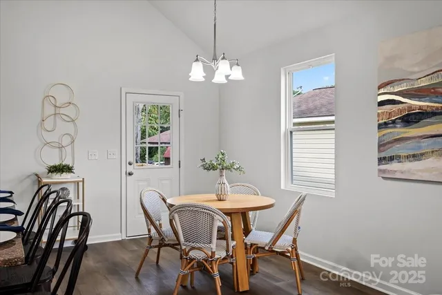 a dining room with furniture a chandelier and wooden floor