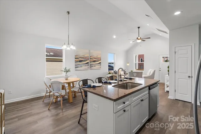 a kitchen with a sink stove and wooden floor
