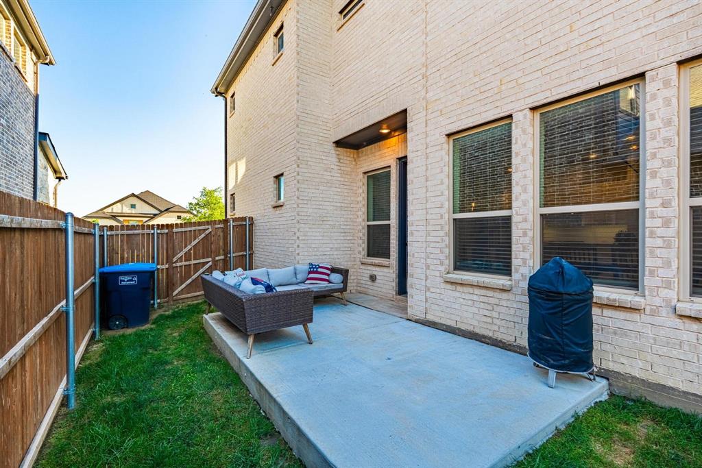 9341 Loggerhead Way Fort Worth, TX 76118 - Photo 32 of 35 Backyard patio featuring a concrete slab, a wooden privacy fence, and a brick exterior