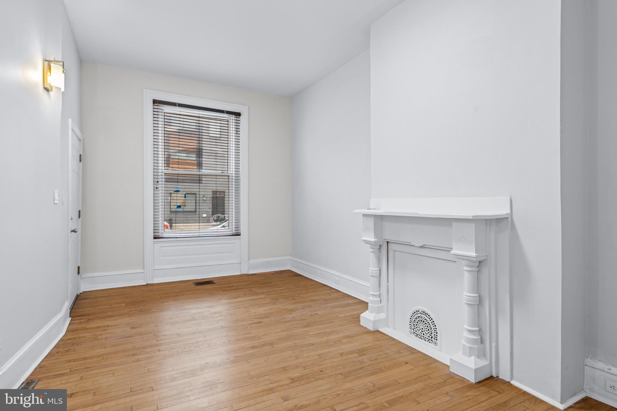 2303 Christian Street Philadelphia, PA 19146 - Photo 7 of 26 an empty room with wooden floor cabinet and windows