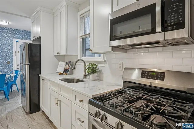 a kitchen with stainless steel appliances granite countertop a stove and a microwave