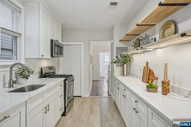 a kitchen with a sink dishwasher a stove and a refrigerator with wooden floor